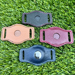 4 AirTag holders laid out on the lawn